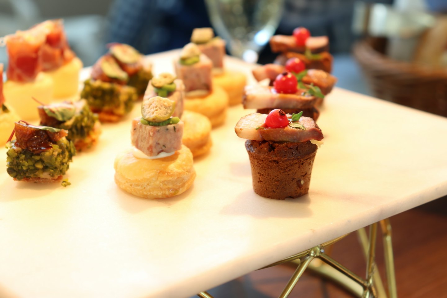 Gourmet canapés arranged on a white marble serving tray.