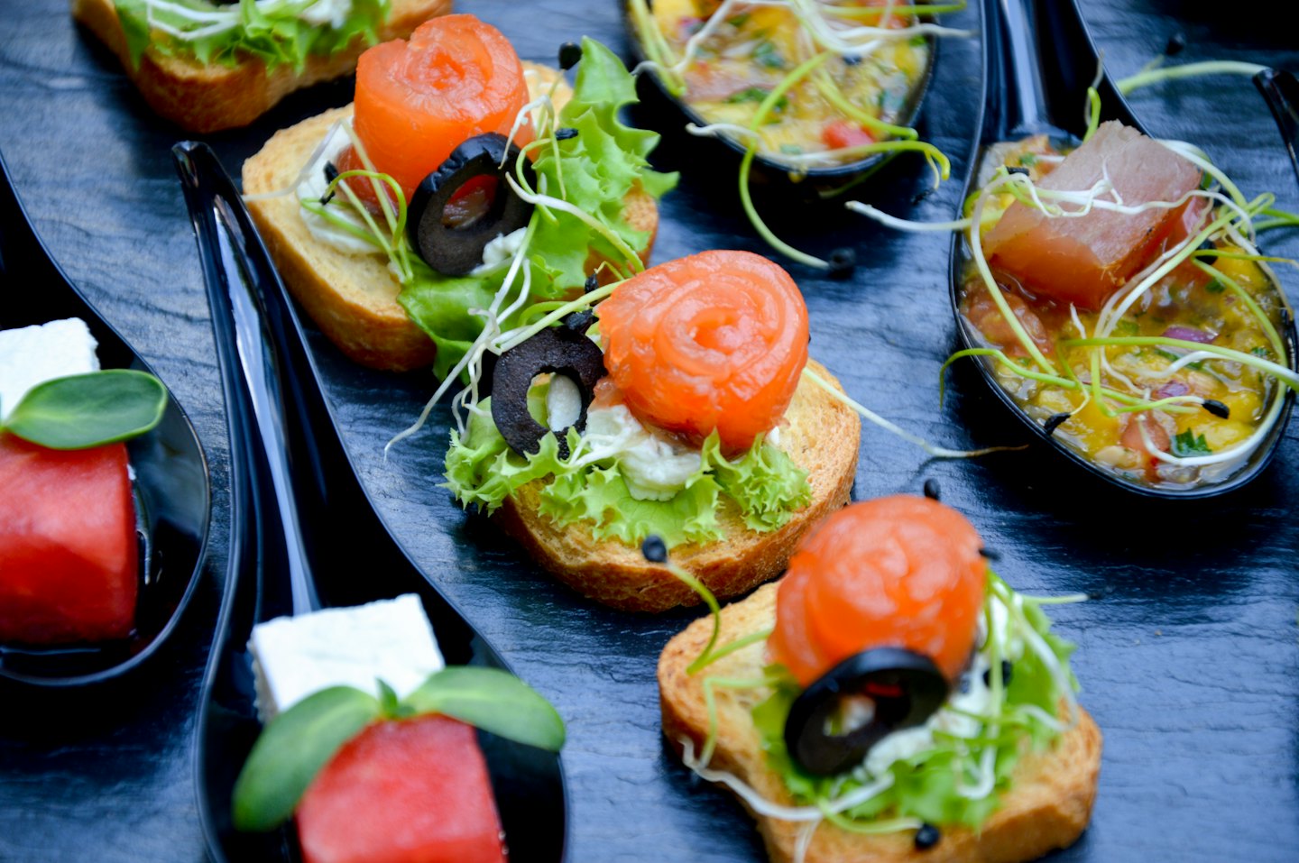 Elegant appetizers arranged on a dark slate tray.
