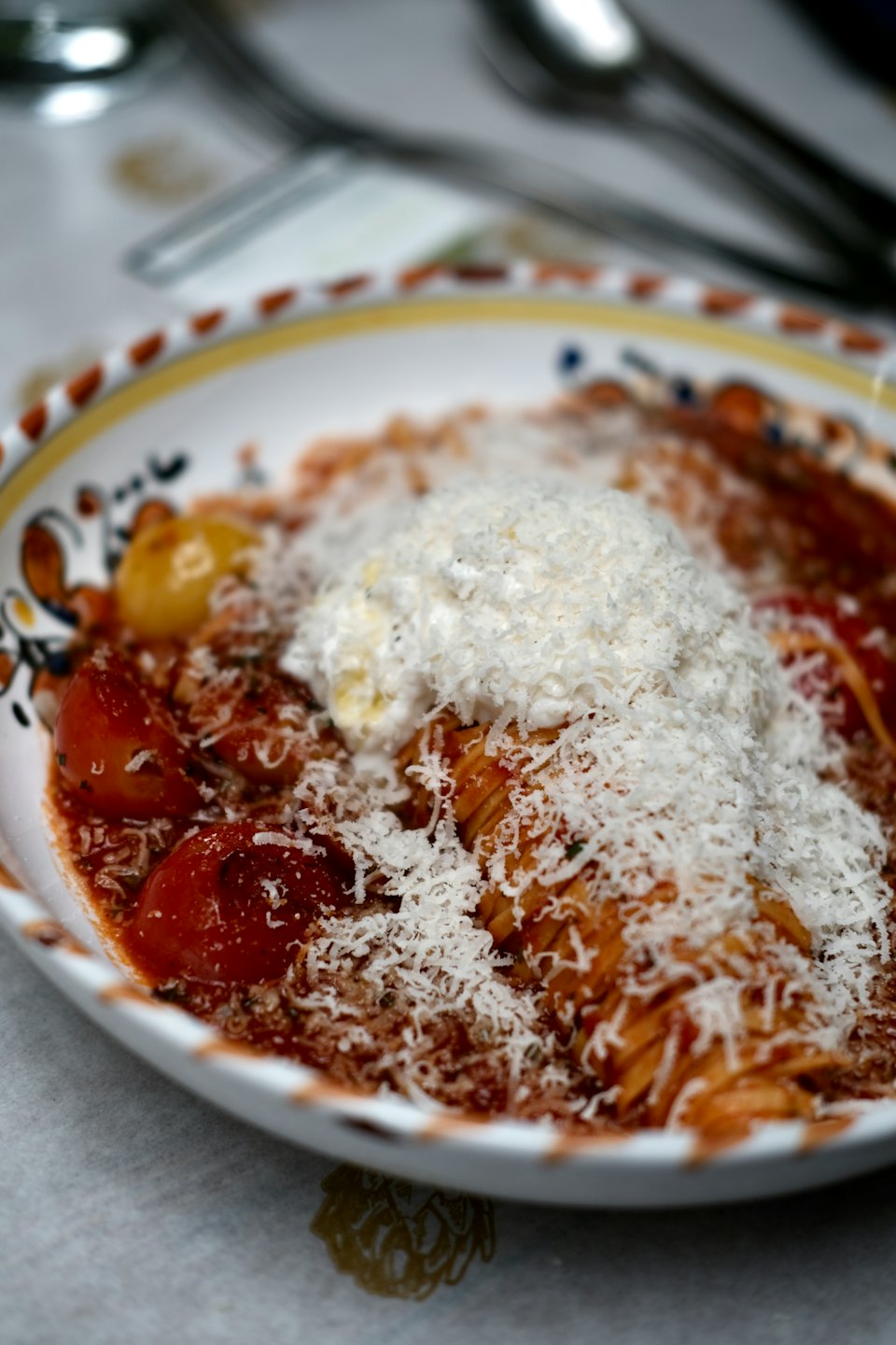 Pasta with tomato sauce and ricotta in a ceramic bowl.